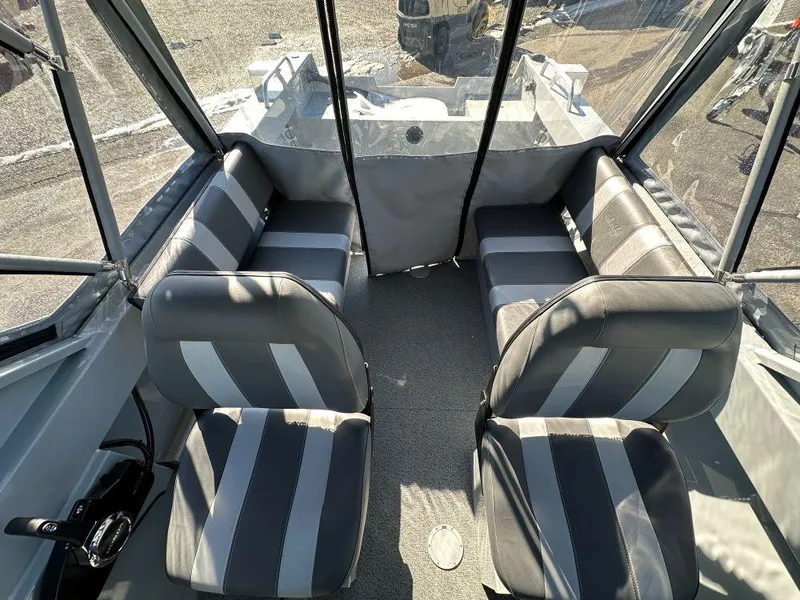 Slide: The Image of Interior of 2025 Hewescraft 180 Sportsman boat with gray seating and striped upholstery. - 7