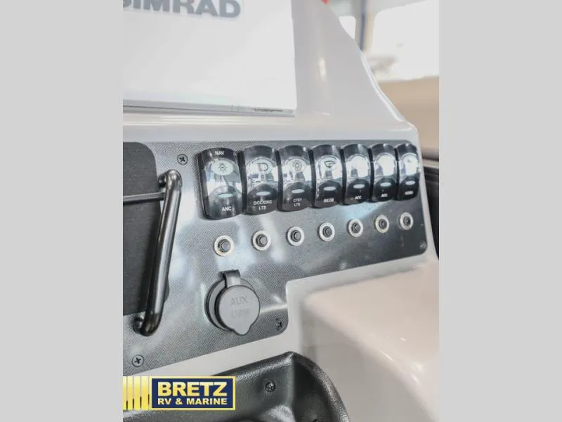 Slide: The Image of Control panel of 2025 Aria 22QC boat with labeled switches and AUX port. - 13