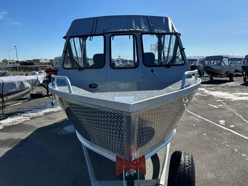 Slide: The Image of 2025 Hewescraft 210 Sea Runner ET boat on trailer in sunny marina. - 2