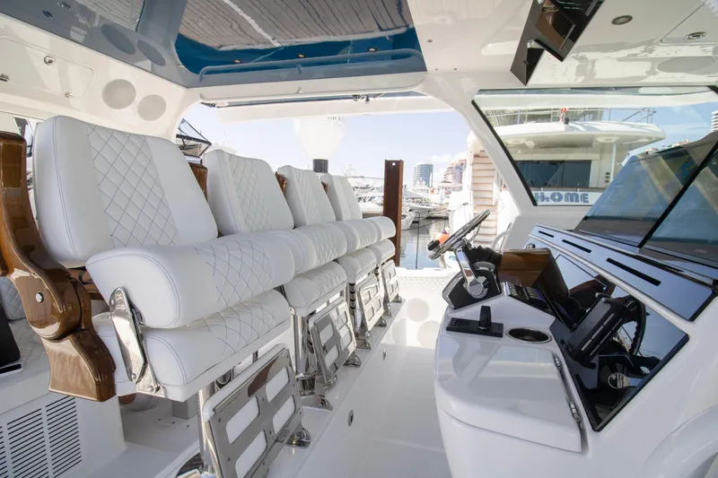 Slide: The Image of 2025 HCB 56 Suenos GIX luxury yacht interior with white quilted seating and modern controls. - 11
