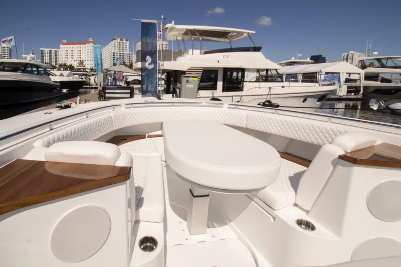 Slide: The Image of 2025 HCB 56 Suenos GIX luxury yacht interior with white seating and table at marina. - 9