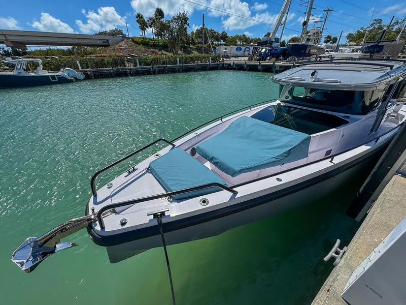 Slide: The Image of 2024 Axopar Sun Top boat docked in a serene marina setting. - 10