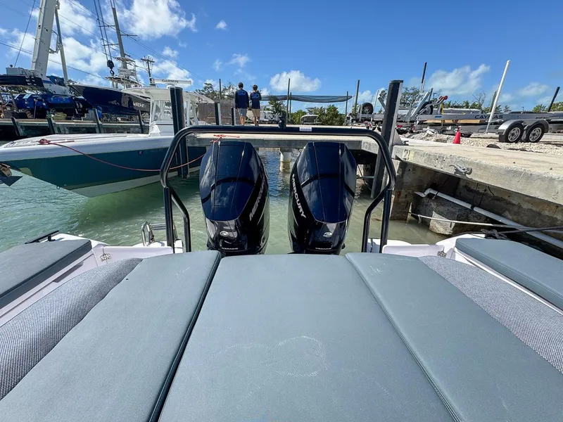 Slide: The Image of 2024 Axopar Sun Top boat with dual outboard motors docked at marina. - 13