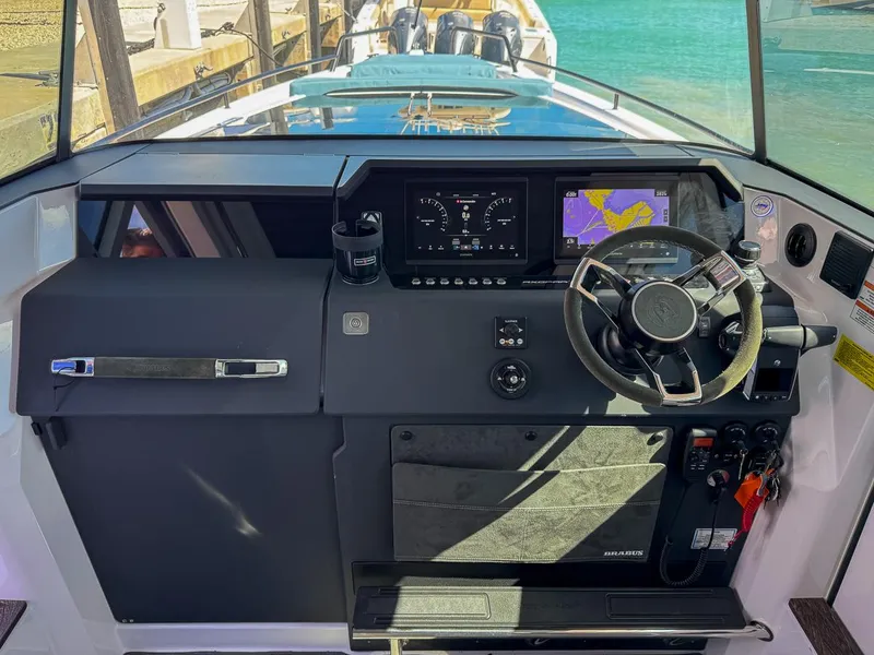 Slide: The Image of 2024 Axopar Sun Top dashboard with navigation screens and steering wheel. - 16