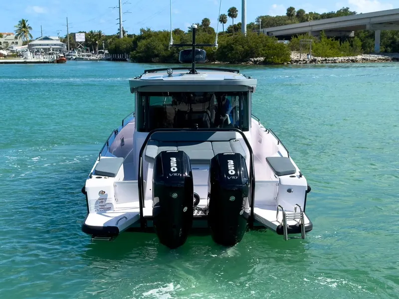 Slide: The Image of 2024 Axopar Sun Top boat with dual outboard engines on turquoise water. - 4