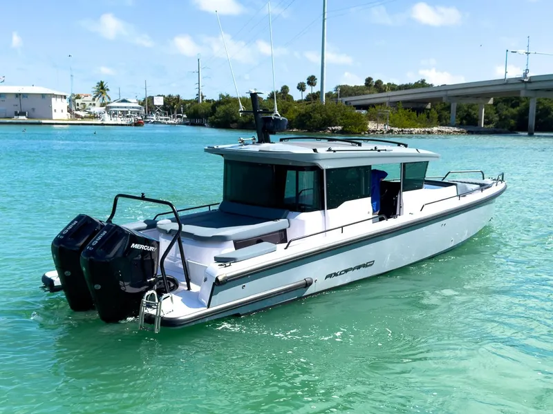 Slide: The Image of 2024 Axopar Sun Top boat on clear turquoise water, featuring sleek design and dual engines. - 6