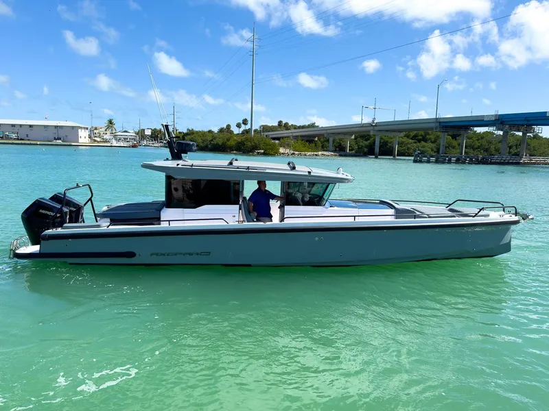 Slide: The Image of 2024 Axopar Sun Top boat on turquoise water under a clear blue sky. - 7