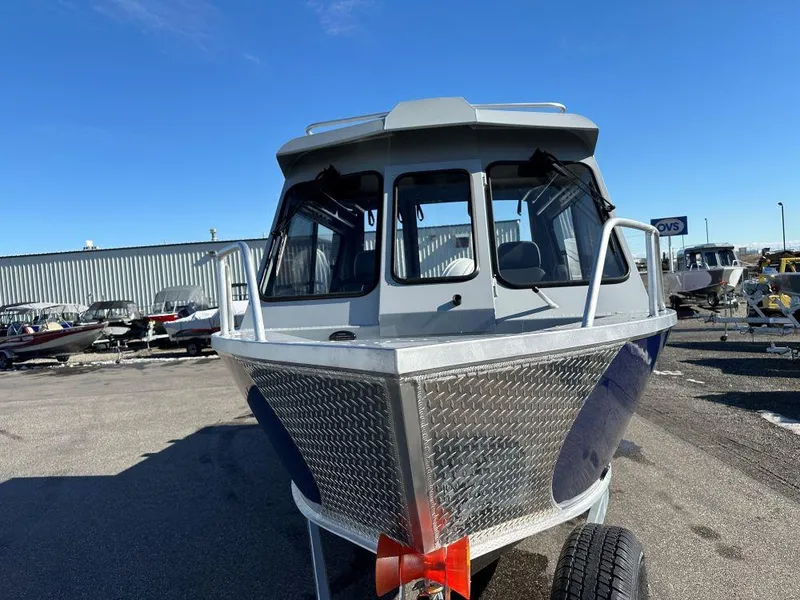 Slide: The Image of 2025 Hewescraft 210 Sea Runner ET HT boat, front view, parked outdoors. - 2