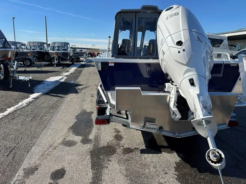 Slide: The Image of 2025 Hewescraft 210 Sea Runner ET HT boat with powerful outboard motor, parked outdoors. - 3