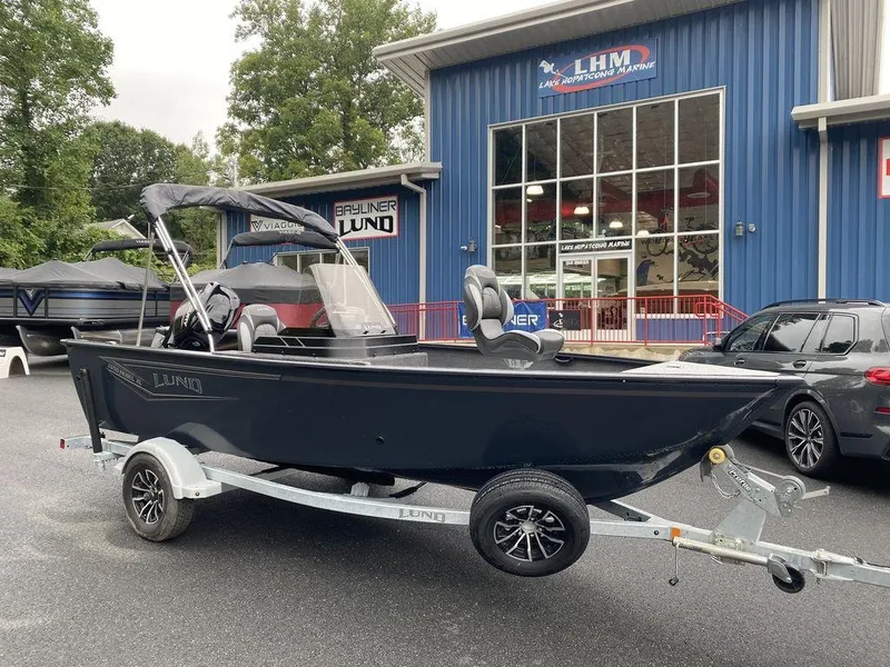 The Image of 2025 Lund 1650 Rebel XL boat on trailer outside dealership. - 1