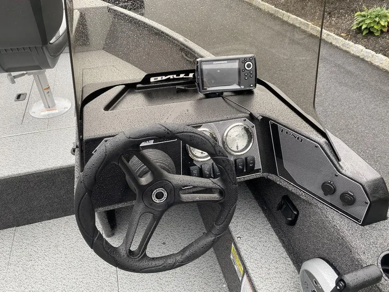 Slide: The Image of 2025 Lund 1650 Rebel XL boat dashboard with steering wheel and navigation system. - 15