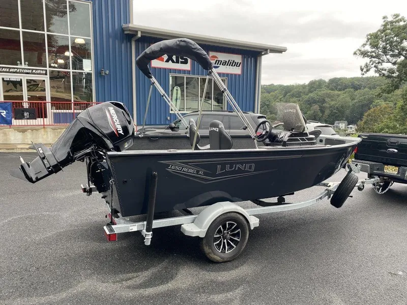 Slide: The Image of 2025 Lund 1650 Rebel XL boat on trailer, parked outside dealership. - 4