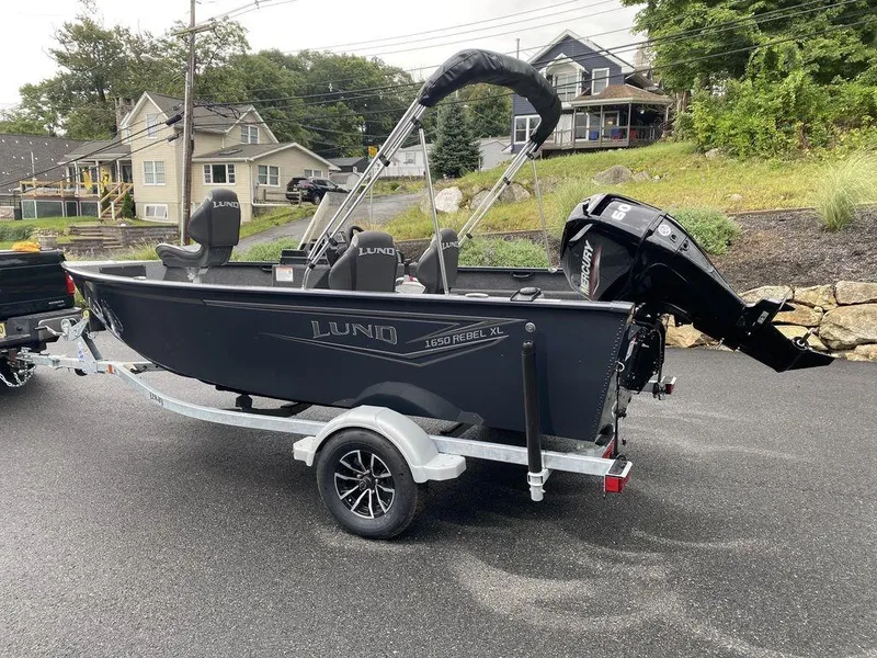 Slide: The Image of 2025 Lund 1650 Rebel XL boat on trailer, parked in residential area. - 5