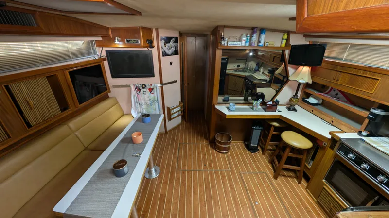 Slide: The Image of 1987 Sea Ray 390 Express Cruiser interior with kitchen, seating, and wooden flooring. - 11