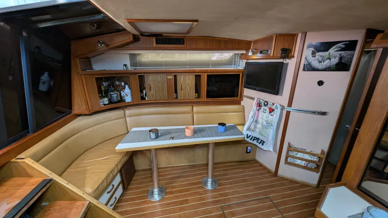 Slide: The Image of 1987 Sea Ray 390 Express Cruiser interior with wood accents and cozy seating area. - 13
