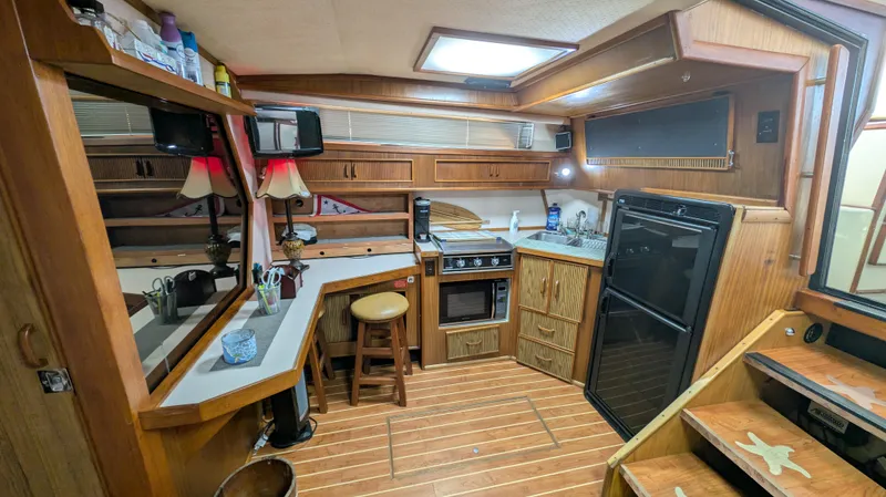 Slide: The Image of 1987 Sea Ray 390 Express Cruiser kitchen with wood cabinetry and modern appliances. - 14