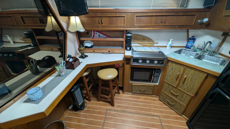 Slide: The Image of 1987 Sea Ray 390 Express Cruiser kitchen with wood cabinetry and modern appliances. - 16