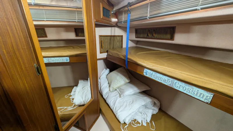 Slide: The Image of 1987 Sea Ray 390 Express Cruiser cabin with bunk beds and wooden interior. - 18