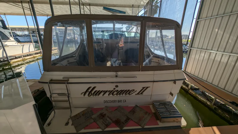 Slide: The Image of 1987 Sea Ray 390 Express Cruiser docked, rear view with "Hurricane II" name visible. - 2