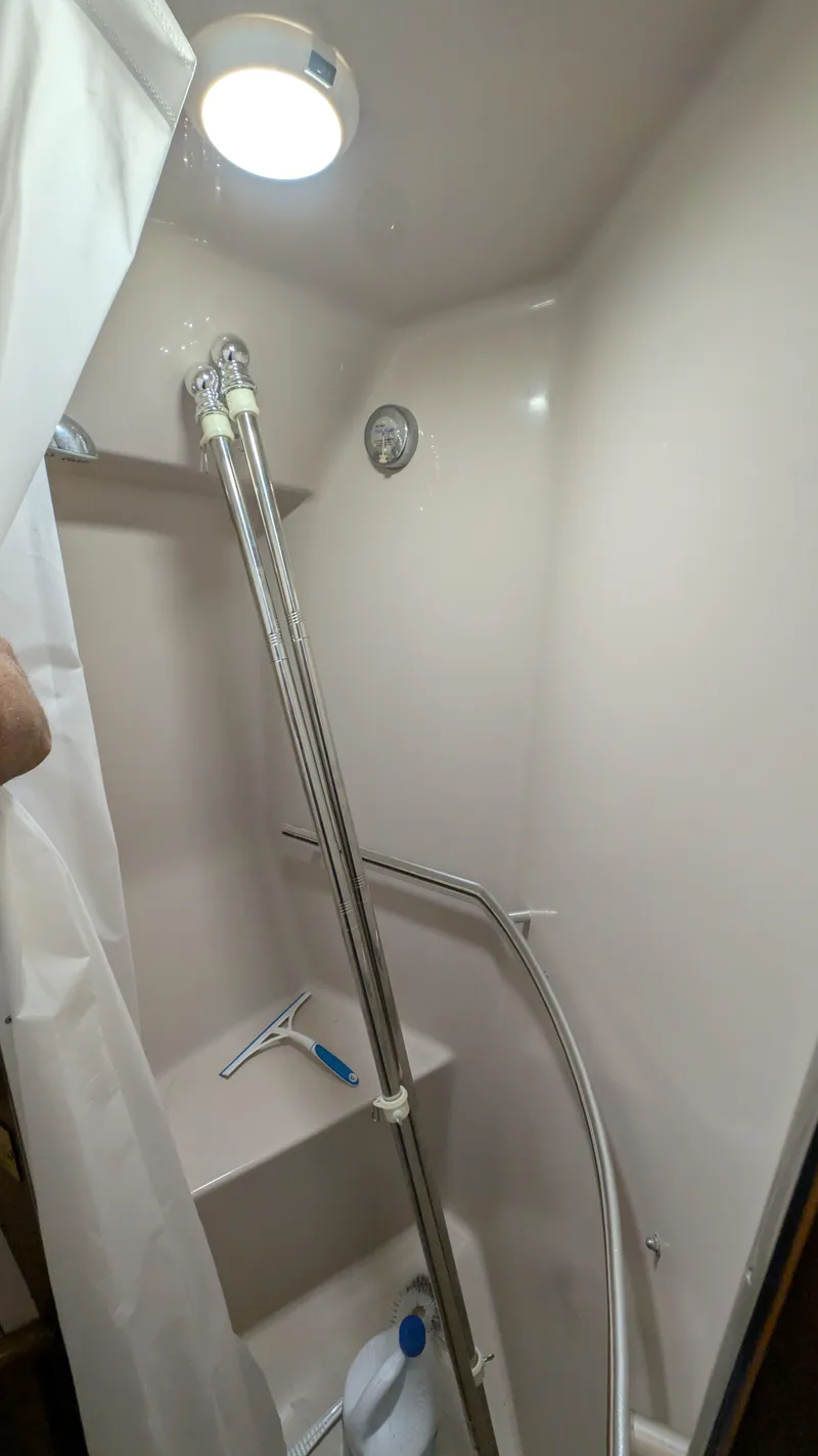 Slide: The Image of Shower area in 1987 Sea Ray 390 Express Cruiser with white walls and stainless steel fixtures. - 20