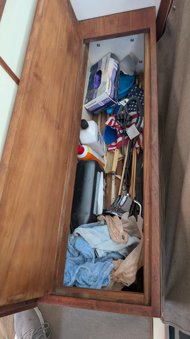 Slide: The Image of Storage compartment on a 1987 Sea Ray 390 Express Cruiser with various items inside. - 31