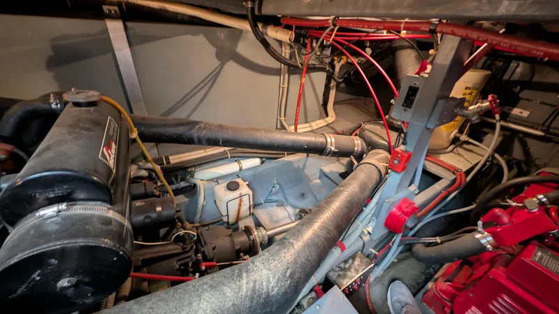 Slide: The Image of Engine room of 1987 Sea Ray 390 Express Cruiser with visible machinery and wiring. - 34