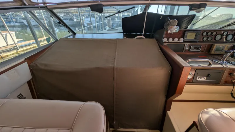 Slide: The Image of 1987 Sea Ray 390 Express Cruiser cockpit with covered dashboard and seating area. - 8
