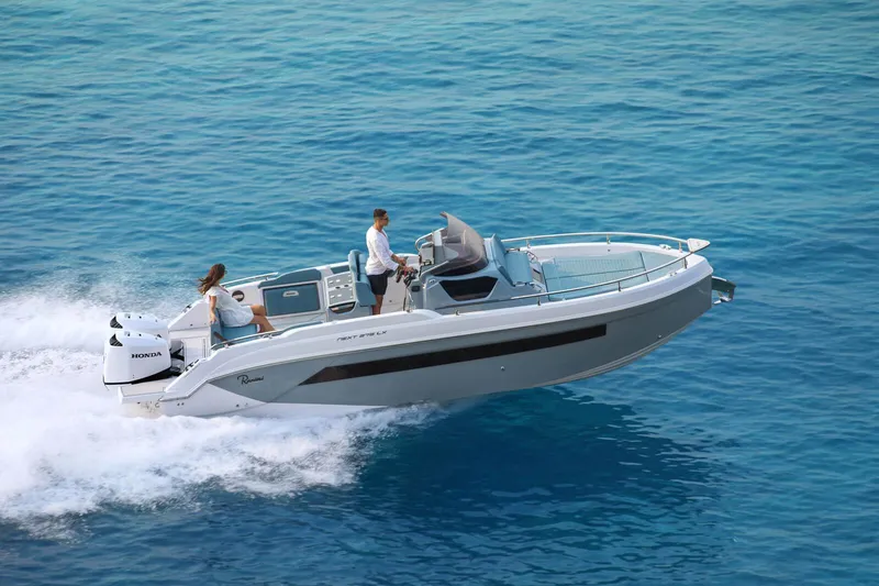 The Image of 2025 Ranieri NEXT 275 LX boat cruising on clear blue water. - 0