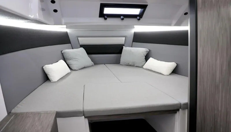 Slide: The Image of 2025 Ranieri NEXT 275 LX cabin interior with modern gray and white bedding. - 13