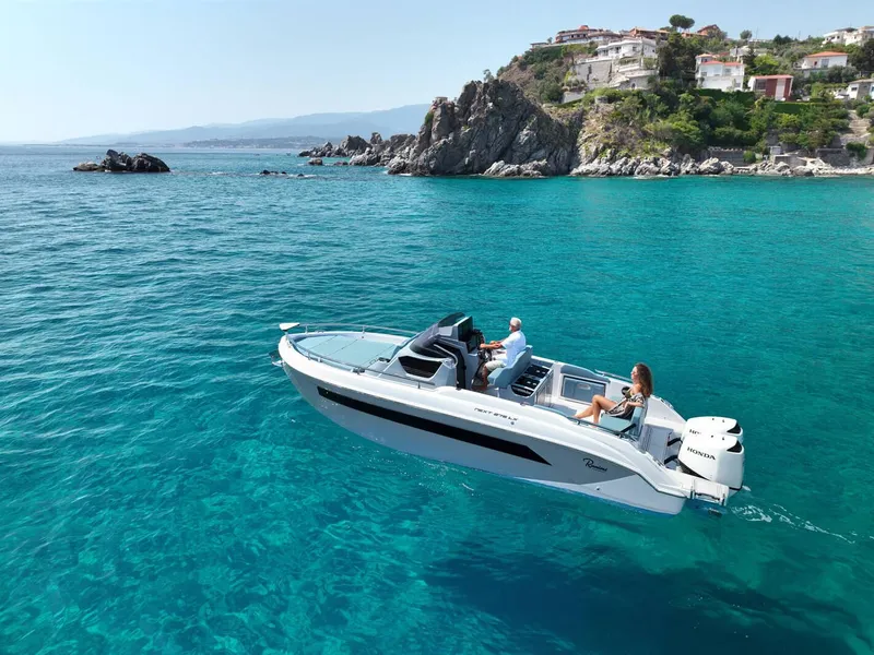 Slide: The Image of 2025 Ranieri NEXT 275 LX cruising in clear blue waters near rocky coastline. - 8