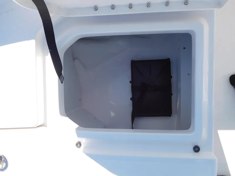 Slide: The Image of 2025 Bayliner Trophy T18Bay storage compartment, open and empty, with visible latch and screws. - 17
