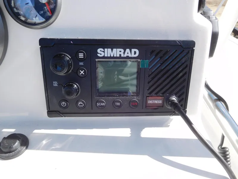 Slide: The Image of Simrad marine radio on 2025 Bayliner Trophy T18Bay dashboard, featuring distress button. - 24