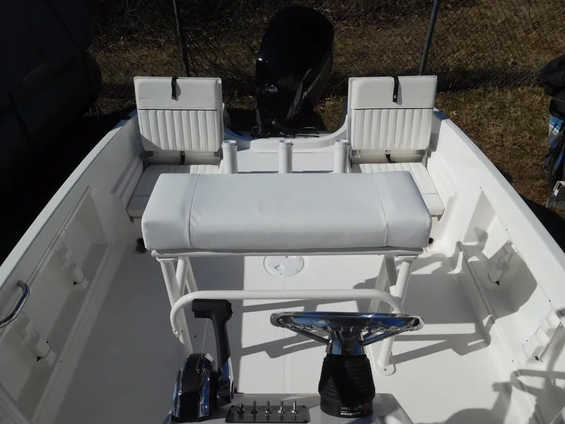 Slide: The Image of 2025 Bayliner Trophy T18Bay boat interior with white seating and steering console. - 27