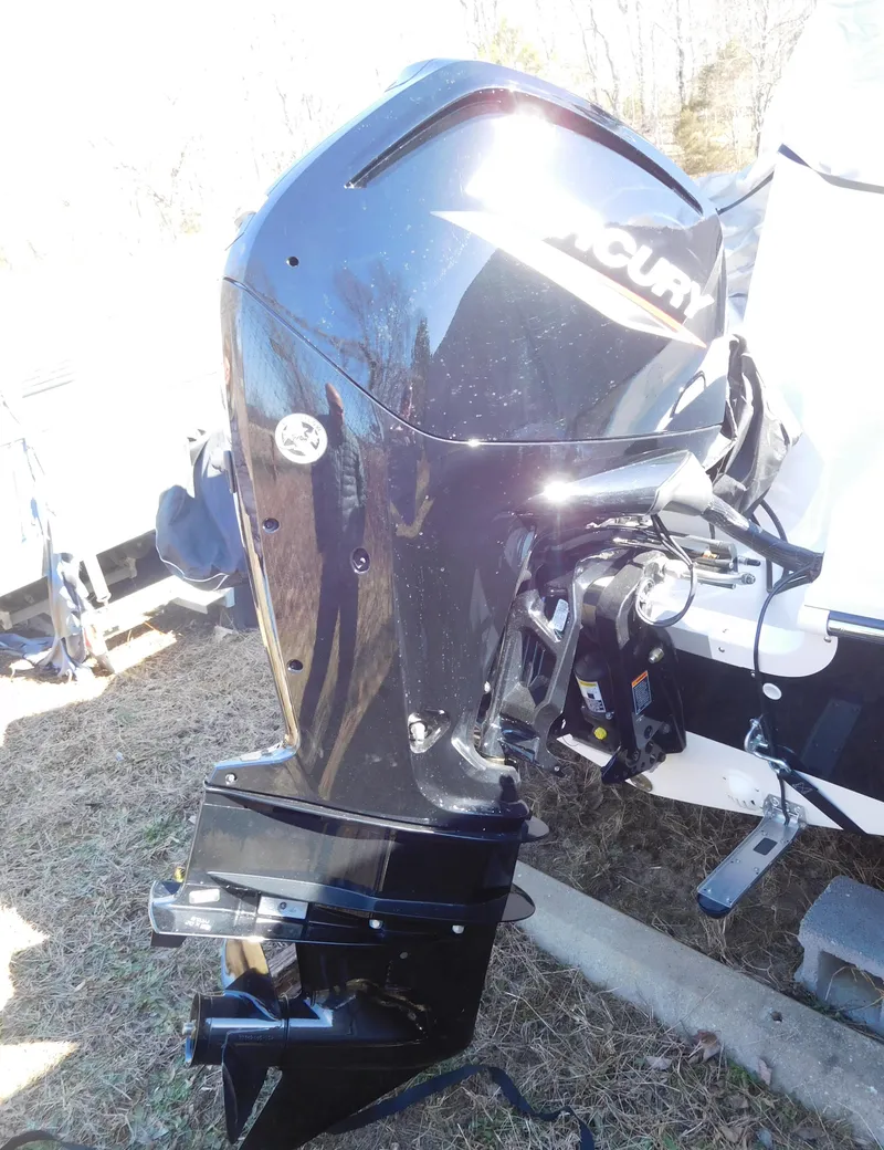 Slide: The Image of 2025 Bayliner Trophy T18Bay with Mercury outboard motor, parked on grass. - 32