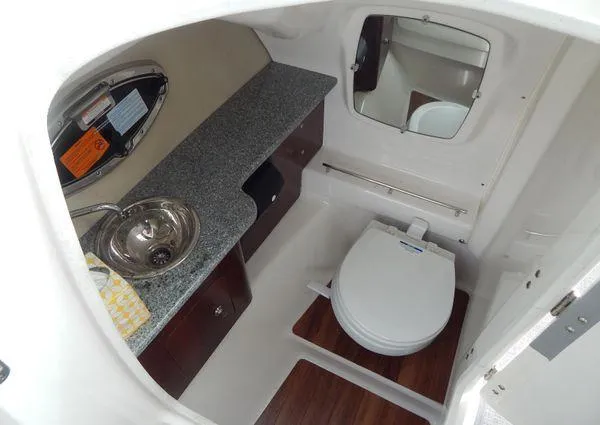 Slide: The Image of 2015 Chaparral 284 Sunesta boat bathroom with sink, toilet, and mirror. - 14
