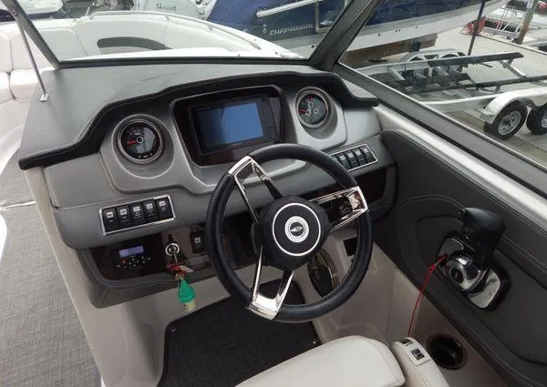 Slide: The Image of 2015 Chaparral 284 Sunesta boat dashboard with steering wheel and control panel. - 20