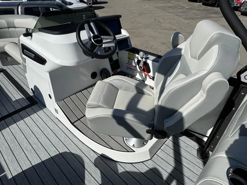 Slide: The Image of 2025 Montara 25' SURF BOSS 2.0 CWDH boat interior with sleek captain's chair and modern dashboard. - 18