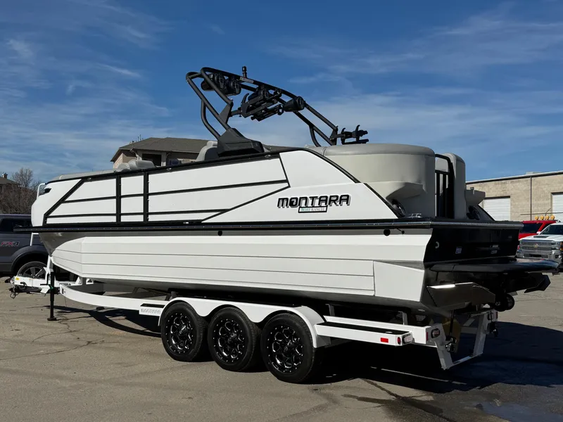 Slide: The Image of 2025 Montara 25' SURF BOSS 2.0 CWDH boat on trailer, parked outdoors. - 3