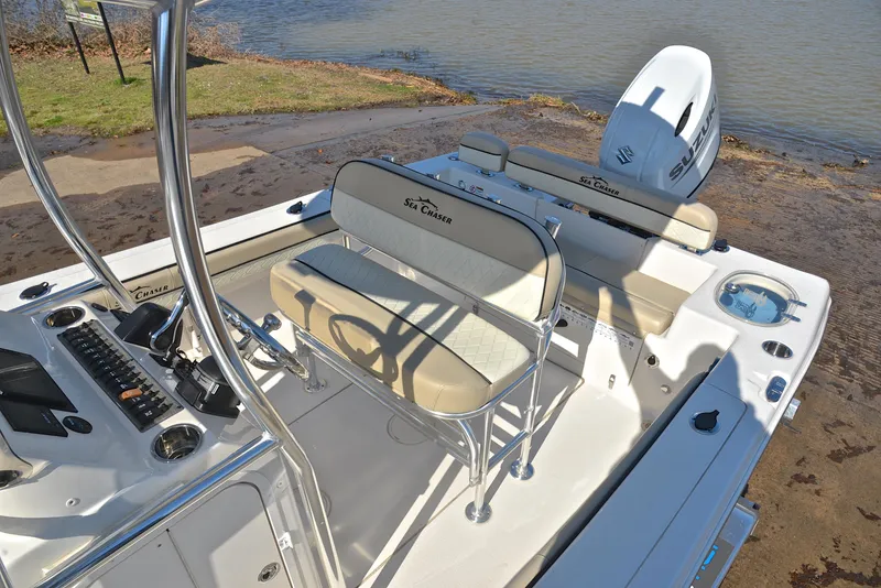 Slide: The Image of 2022 Sea Chaser 22 HFC boat interior with seating and controls by the water. - 21