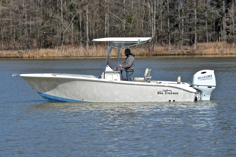 Slide: The Image of 2022 Sea Chaser 22 HFC boat cruising on a calm lake with trees in the background. - 7