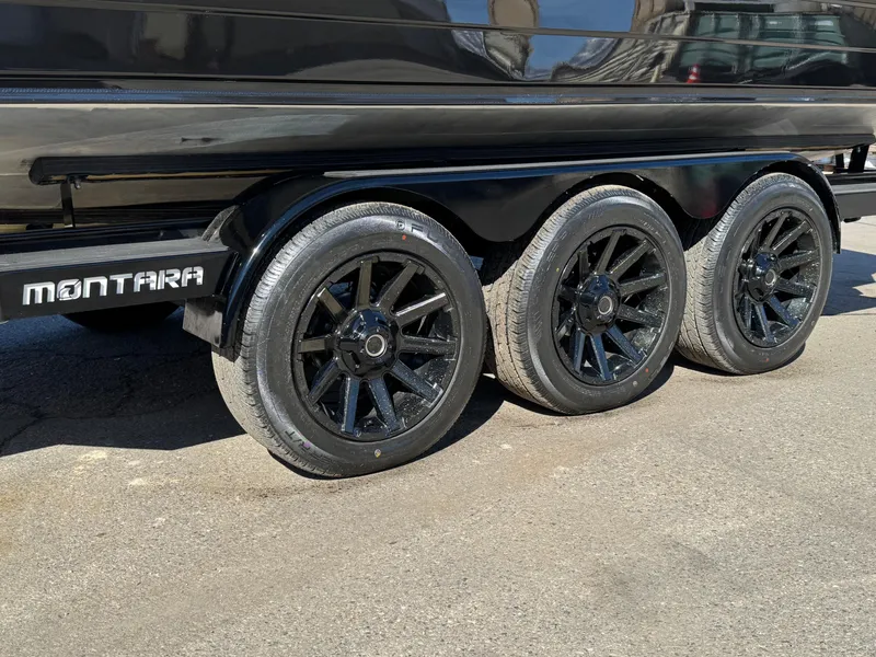 Slide: The Image of 2025 Montara 25' SURF BOSS 2.0 SL trailer with black wheels on pavement. - 10