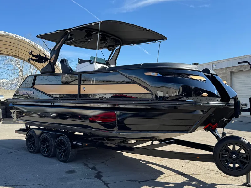 Slide: The Image of 2025 Montara 25' SURF BOSS 2.0 SL boat on trailer, sleek black design. - 12