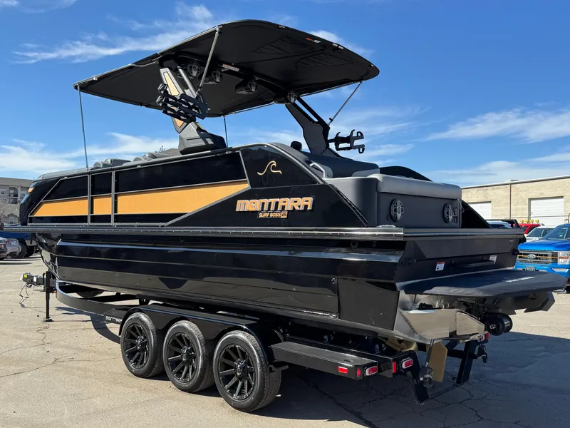 Slide: The Image of 2025 Montara 25' SURF BOSS 2.0 SL boat on trailer, sleek black design. - 3