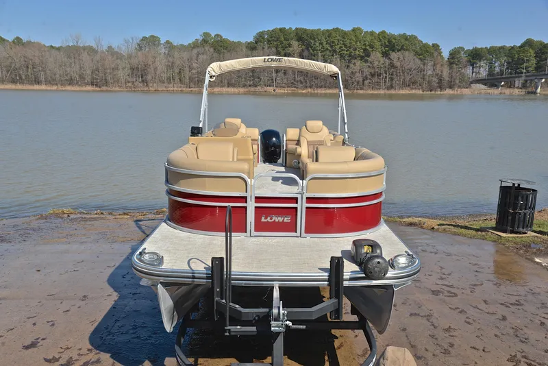 Slide: The Image of 2021 Lowe SS250 pontoon boat on trailer by a lake. - 17