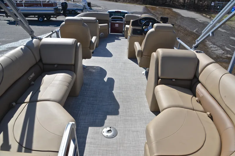 Slide: The Image of 2021 Lowe SS250 pontoon boat interior with beige seating and steering console. - 18