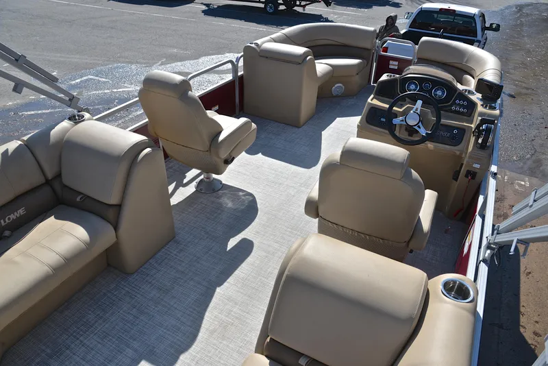 Slide: The Image of Interior of 2021 Lowe SS250 pontoon boat with beige seating and steering console. - 19