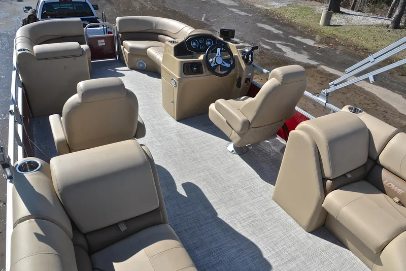 Slide: The Image of 2021 Lowe SS250 pontoon boat interior with beige seating and steering console. - 20