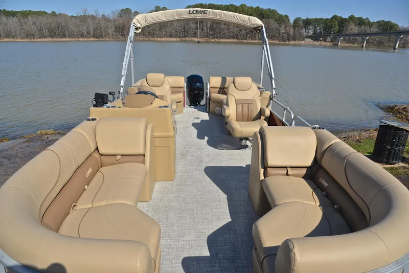 Slide: The Image of 2021 Lowe SS250 pontoon boat with spacious seating on a calm lake. - 21