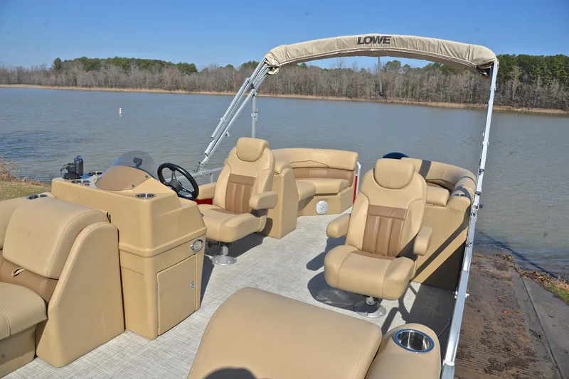 Slide: The Image of 2021 Lowe SS250 pontoon boat with beige seating on a calm lake. - 23