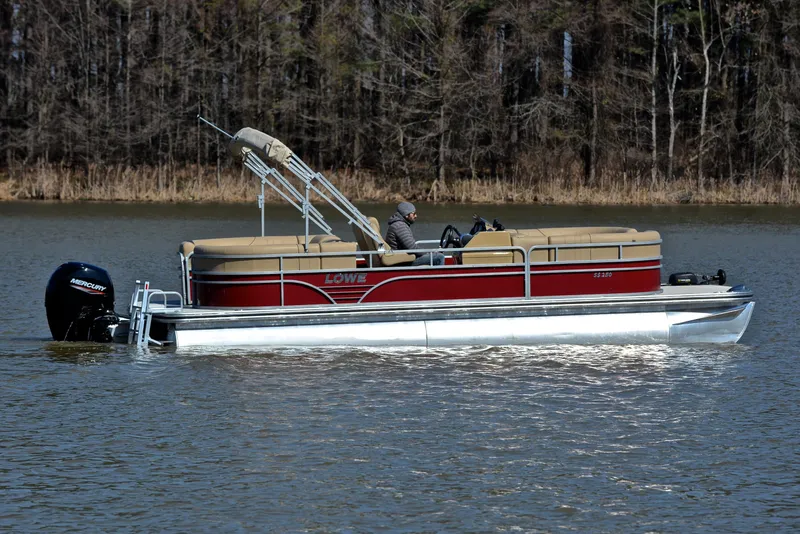 Slide: The Image of 2021 Lowe SS250 pontoon boat cruising on a calm lake. - 6